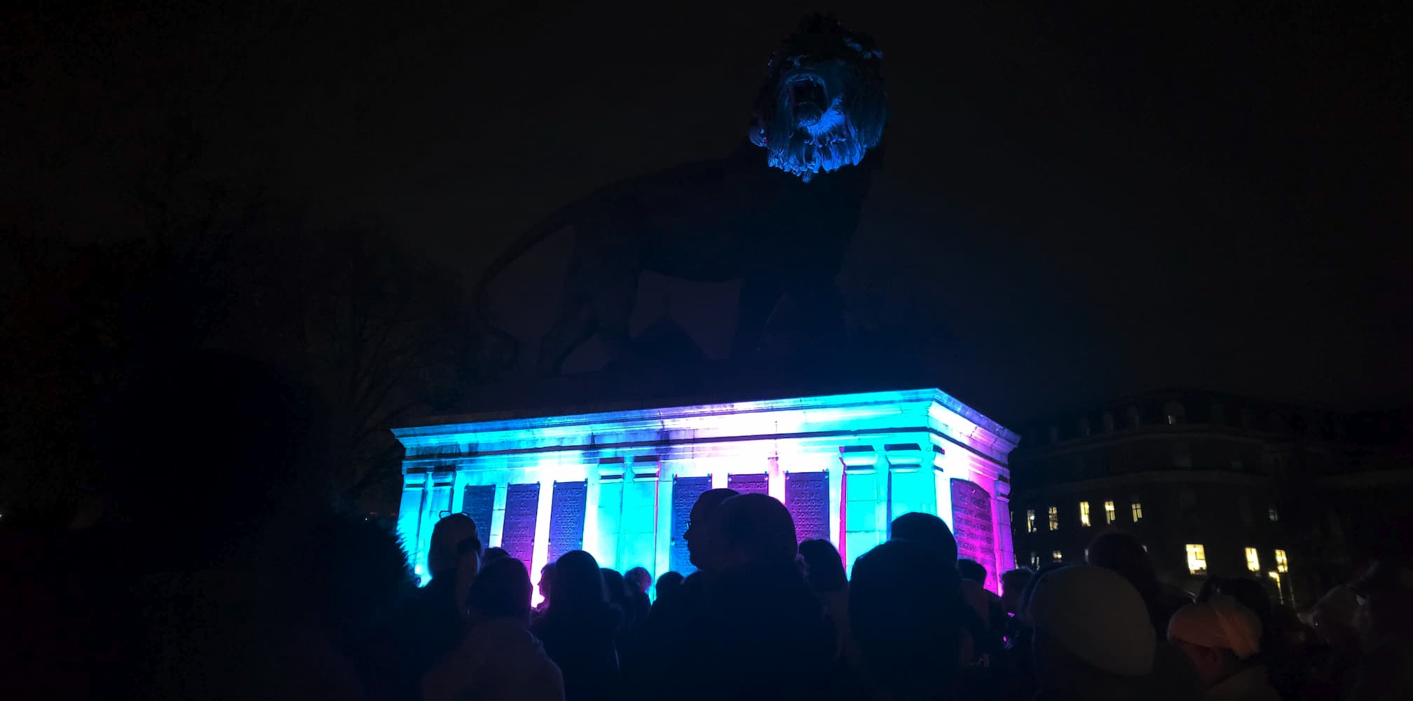 The crowd gathered before the lion statue